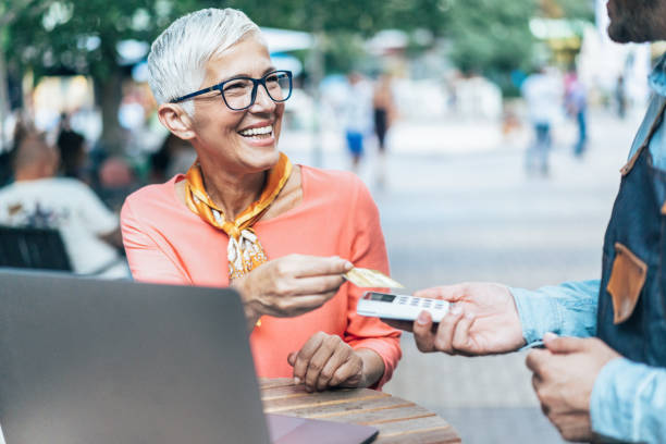 istock Mature woman paying contactless 1184589117