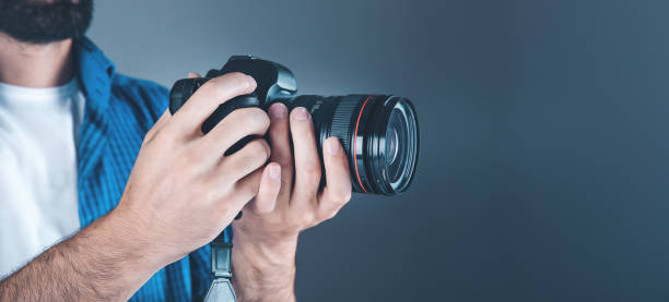 istock photographer hand camera on gray background 1184590408