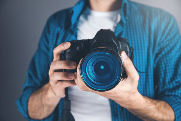 istock photographer hand camera on gray background 1184590424
