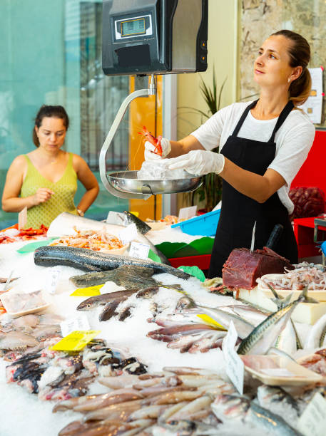 istock Confident female weighing raw prawns on scales 1184590870