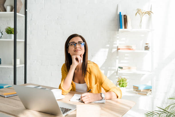 istock beautiful dreamy freelancer working with laptop in home office 1184595427