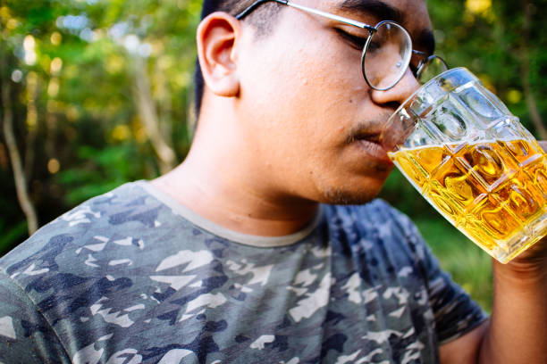 istock brown skin man happily drink beer 1184595510