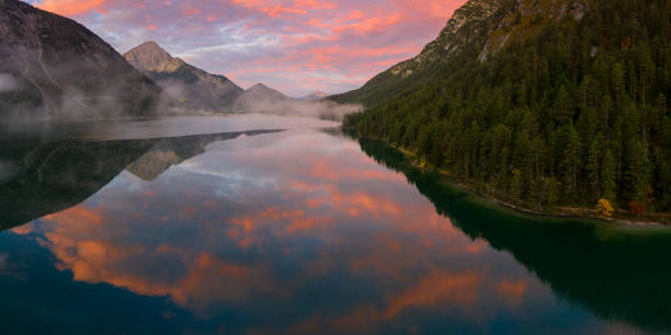 istock reflection of red sky clouds in lake heiterwanger see in austria 1184595607