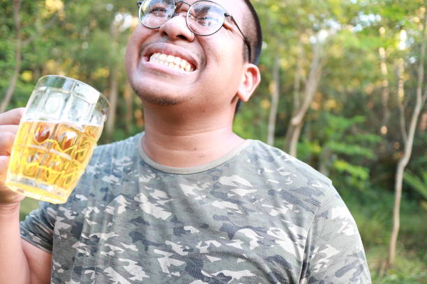 istock brown skin man happily drink beer 1184595811