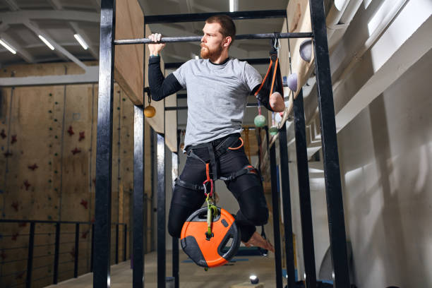 istock Muscled sportsman with physical disability performing pull ups with load 1184596151