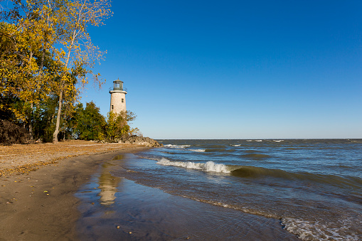 The historic Pelee Island Lighthouse, built in 1833, reflecting on its Lake Erie shoreline in autumn - Ontario, Canada