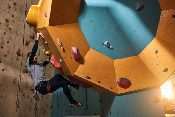 istock Strong climber with physical disability moving up on steep rock wall 1184597064