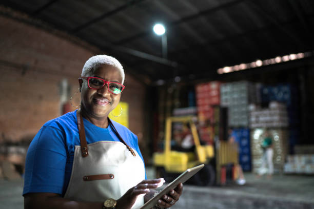 istock Portrait of smiling employee using digital tablet at warehouse 1184598563