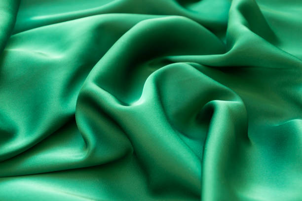 istock Smooth wavy elegant emerald green silk or satin luxury cloth texture background 1184600072