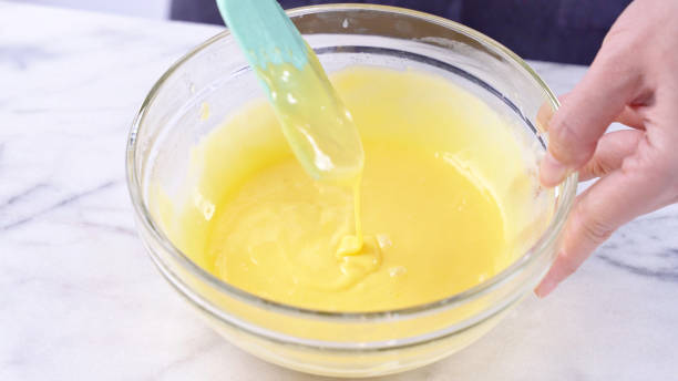 istock Mixing egg yolk into cake batter with green rubber spatula mixer tool stirring until smooth and blend well in a glass bowl. 1184602306