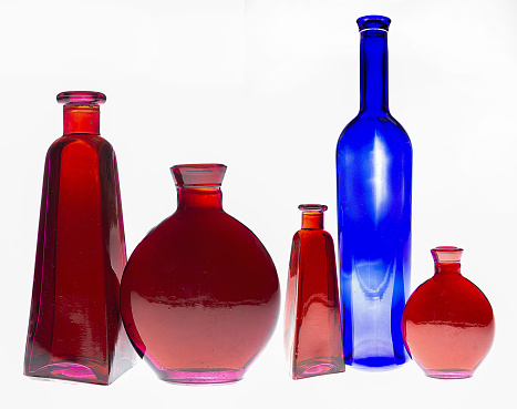 Magenta glass bottles with water and water drops