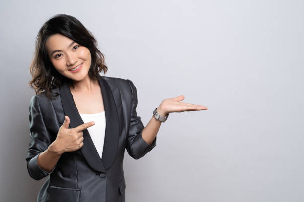 istock Happy woman present the copy space isolated over white background 1184604137