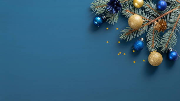 istock Christmas composition with green pine twigs, gloden and blue decorations, confetti on blue background with copy space. Top view, Flat lay. Xmas banner mockup, vintage postcard template 1184606608