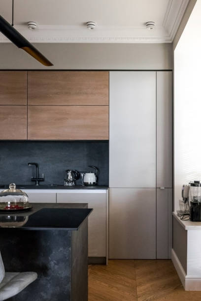 istock Minimalist wooden grey kitchen with handleless facades, impressive lamp, kitchen island and autumn decor, smart storage system. Kitchen room organization 1184606883