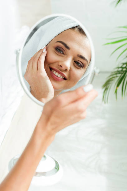 istock reflection attractive and smiling woman looking at mirror at morning 1184607195