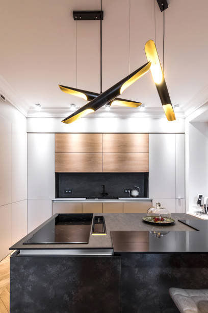 istock Minimalist wooden grey kitchen with handleless facades, impressive lamp, kitchen island and autumn decor, smart storage system. Kitchen room organization 1184607316