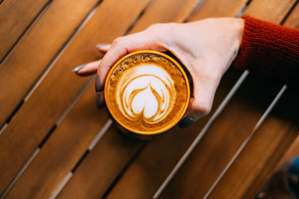 istock Top View Woman Hand Holding Latte 1184610593