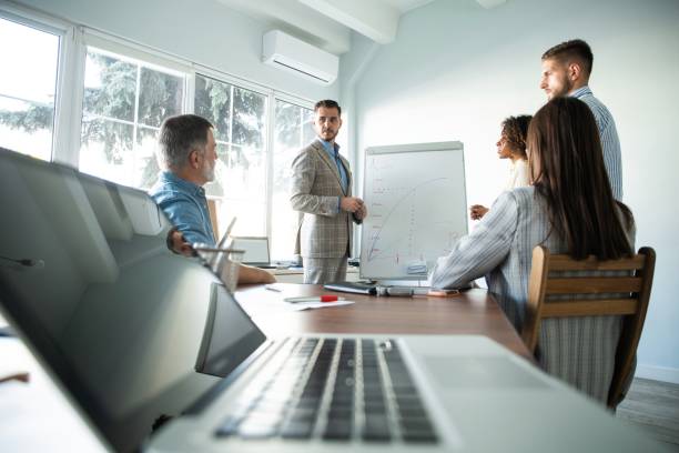 istock Business man making a presentation at office. Business executive delivering a presentation to his colleagues 1184611677