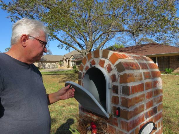 senior man checking mailbox - looking into mailbox imagens e fotografias de stock
