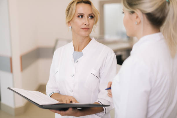 istock Two good-looking female doctor looking at clipboard 1184615227