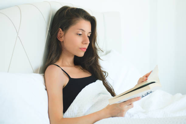istock women reading book in bedroom 1184617046