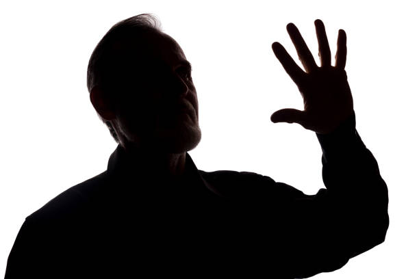 istock Hand old man covers his face, protest - silhouette, concept 1184618176