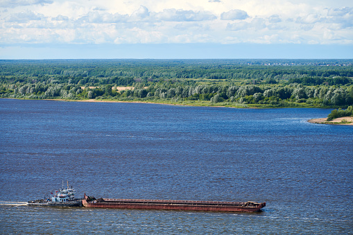 Barge on river sailing to port for cargo. Transport for transportation of crushed stone and sand