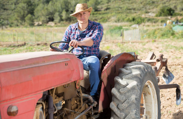 istock Positive man working on farm tractor 1184621983