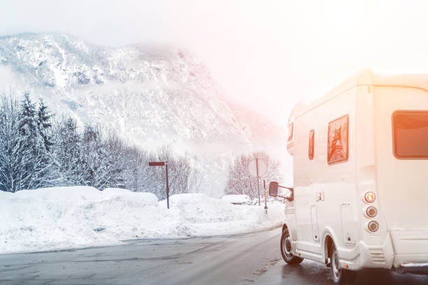 istock Caravan or campervan turning from road with beautiful mountain alpine landscape on background at cold winter season.Family vacation travel, holiday trip in motorhome. Beautiful austrian nature scene 1184623536