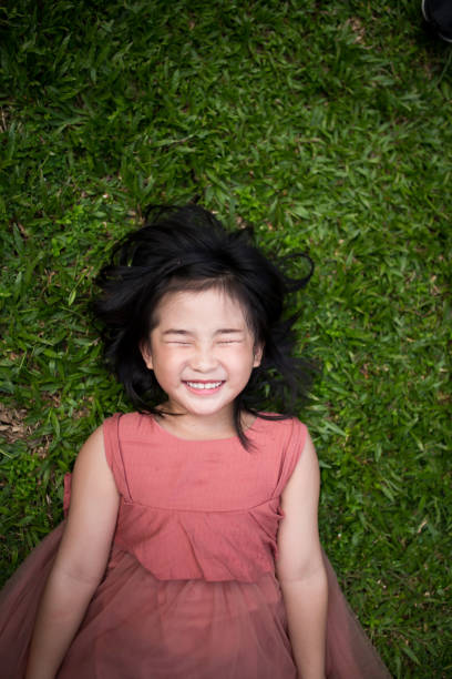 Girl is lying down on grass and enjoy the life.