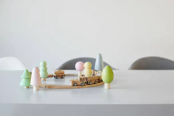 A toy train on rails with colorful wooden trees