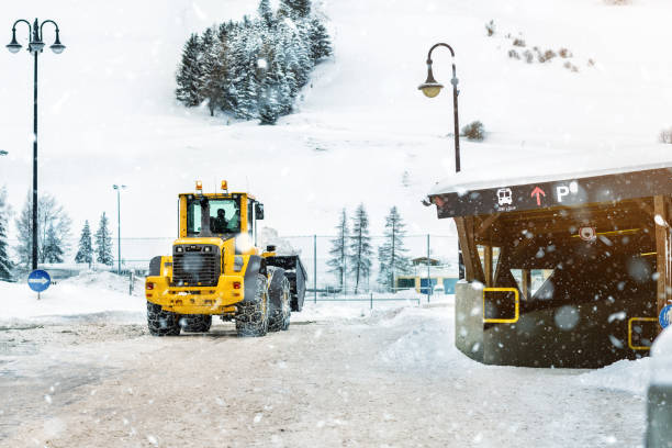 máquina cargadora grande con cadenas de metal de acero que retiran gran pila de nieve de la calle de la ciudad en la región de montaña alpina en invierno. fuertes nevadas después de las secuelas. equipos de limpieza de precipitaciones - snowplow snow parking lot truck fotografías e imágenes de stock