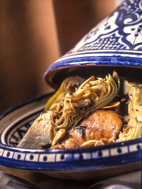 Close-up of Moroccan tajine with chicken, artichoke and nuts. stock photo