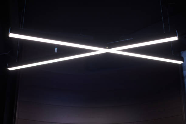 istock Modern office lighting. Thin lamps in office dark ceiling. LED white cold light over workplaces. 1184628387