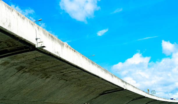 istock Bottom view of elevated concrete highway. Overpass concrete road. Road flyover structure. Modern motorway. Transportation infrastructure. Concrete bridge engineering construction. Bridge architecture. 1184628435