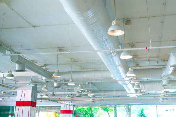 istock Air duct, air conditioner pipe, fire sprinkler system. Air flow and ventilation system. Building interior. Ceiling lamp light with opened light. Interior architecture. Glass wall building. 1184628458