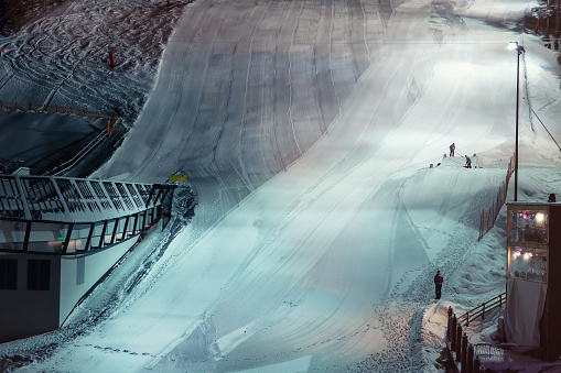 Skiing slope downhill prepared for night performance show with artificial lighting in nighttime at austrian alpine resort Ischgl.