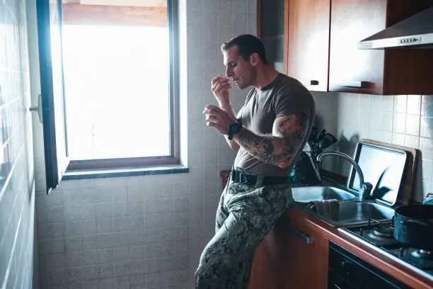 Shot of a young soldier eating a snack in the kitchen