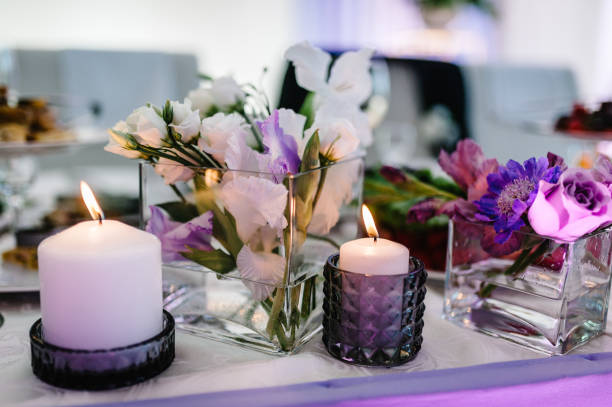 tavolo festivo decorato con composizione di viola, viola, fiori rosa e verde, candele nella sala banchetti. sposi da tavolo nell'area banchetti alla festa di matrimonio. - wedding centerpiece foto e immagini stock