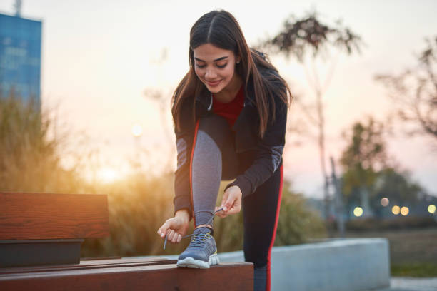 istock Young woman doing exercise in an urban park. 1184630735