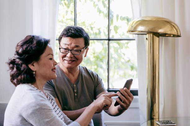 istock Happy seniors using smartphone together 1184631131