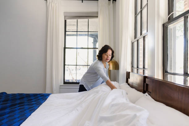 istock Senior woman concentrates while making her bed 1184631234