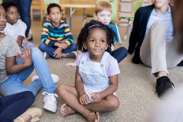 istock Diverse kindergarten children sit on floor for reading time 1184631358