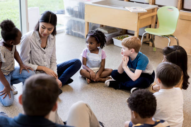 istock Diverse children and teachers sit in circle and play game 1184631379