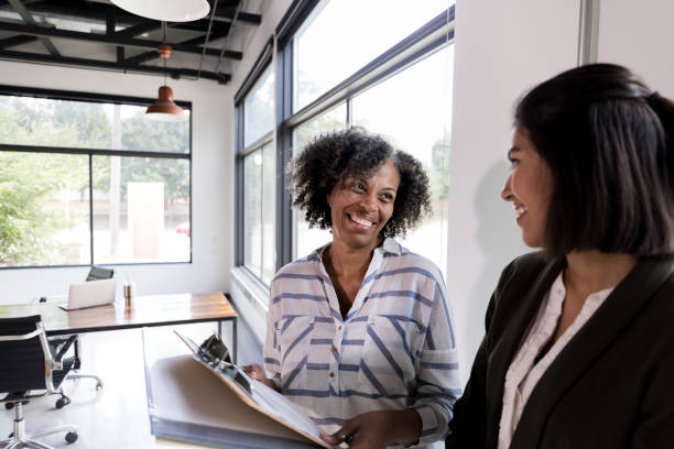 istock Mature office manager explains paperwork to female CEO 1184631456