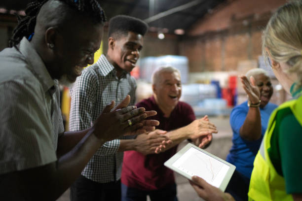 istock Happy employees celebrating together at warehouse 1184631555