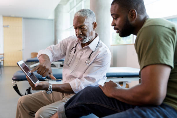 istock Male patient looks with interest at x-rays on digital tablet 1184631581