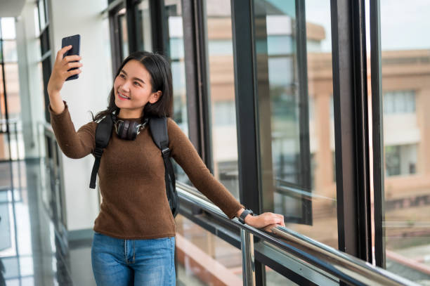 istock Long haired female student taking a selfie at the university 1184631836