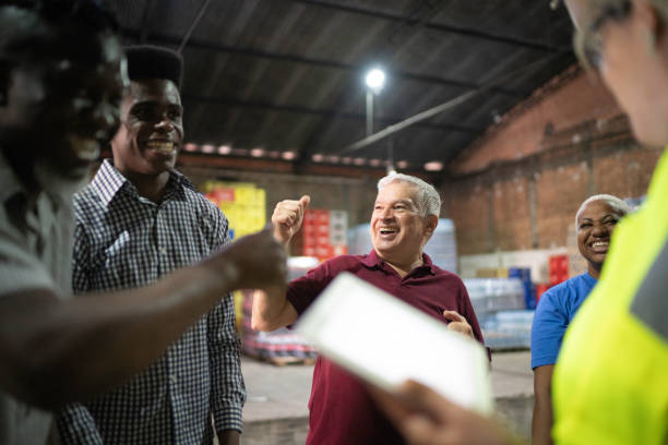 istock Happy employees celebrating together at warehouse 1184632542