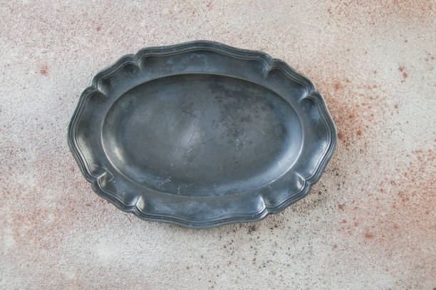 istock Antique pewter oval plate on concrete background. 1184632611